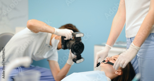 Dentist photographing with professional camera the result of his work. Patient with braces during orthodontic treatment. 4k video screenshot, please use in small size