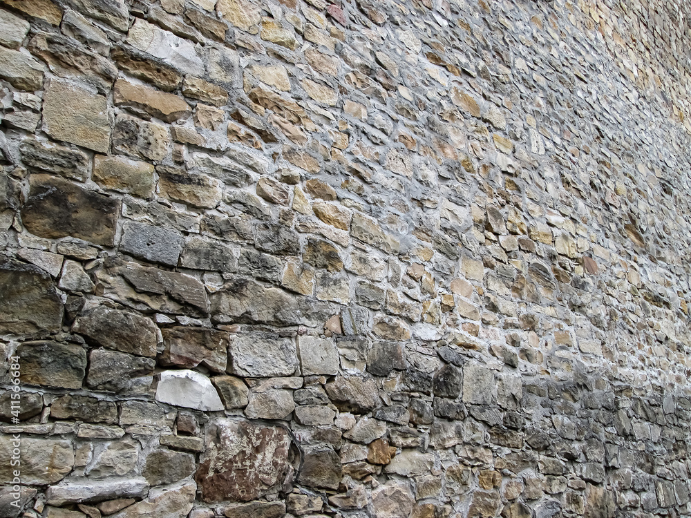 Wall of the old bastion. Historical background with sandy cobblestones. Wall of the old bastion. Historical background with sandy cobblestones.