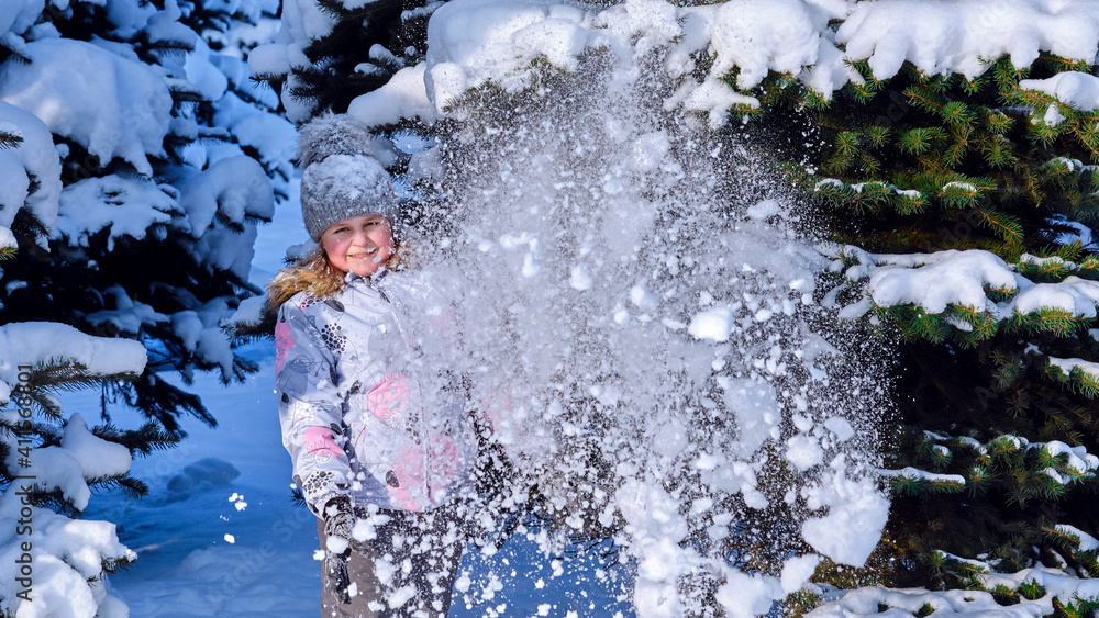 The girl plays with snow. Child rejoices in winter. Happy childhood. The girl plays with snow. Child rejoices in winter. Happy childhood.