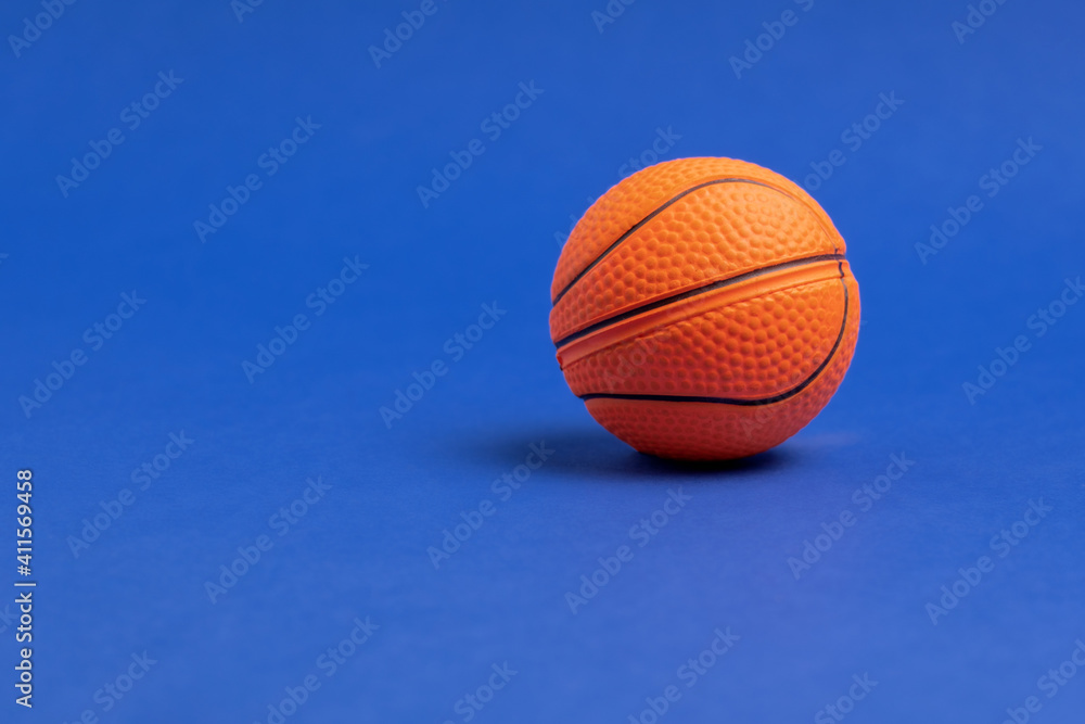 Basketball ball on a blue background. Copy space. Minimal sports wallpaper.