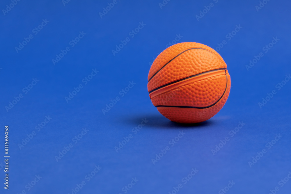 Basketball ball on a blue background. Copy space. Minimal sports wallpaper. Basketball ball on a blue background. Copy space. Minimal sports wallpaper.