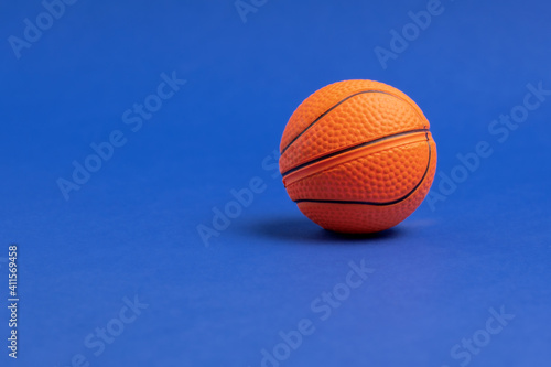 Basketball ball on a blue background. Copy space. Minimal sports wallpaper. © dvulikaia