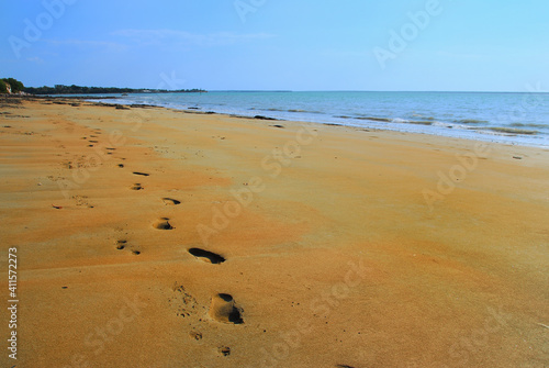 Footprints And Pawprints Side By Side In The Sand On Fannie Bay Beach In Darwin, Australia photo
