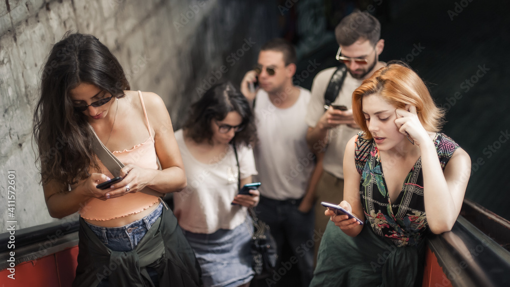 Friends Talking Using Phones Group of friends talk on smartphones while standing on escalator ...