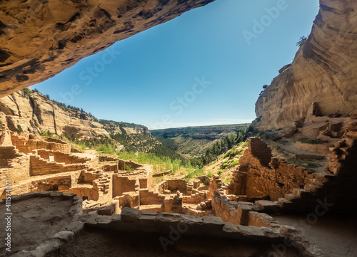 View out from rock overhang to canyon and ruins of old clay town in mesa verde national park in america