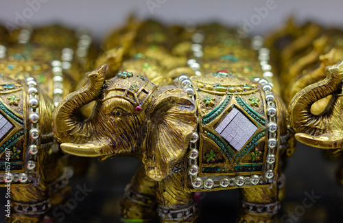 Golden colored elephant figures with trunk up. Souvenir store gift, good luck concepts