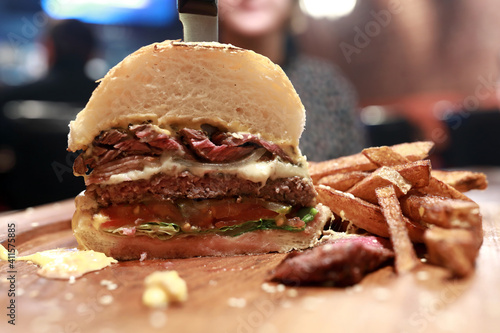 Fotografi Half burger with fries on wooden board