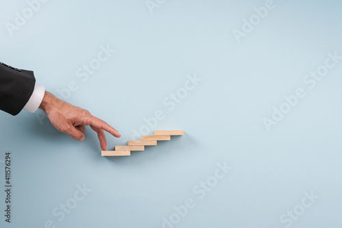 Businessman walking his fingers up the steps
