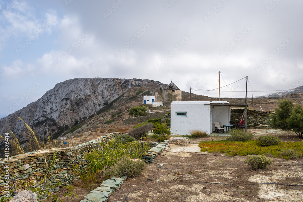 Traditional Greek in the wild part of the island of Folegandros. Old windmills in background. Cyclades, Greece