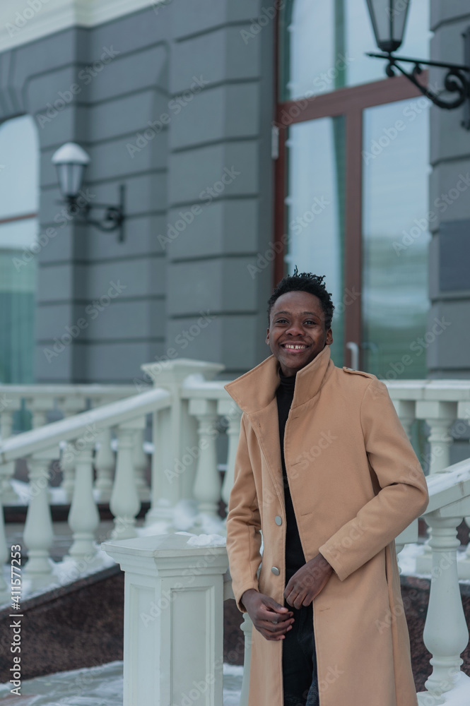 young African American in winter against the backdrop of a majestic building