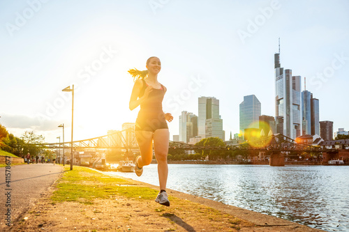 Junge Frau joggt am Mainufer, Frankfurt am Main, Hessen, Deutschland 