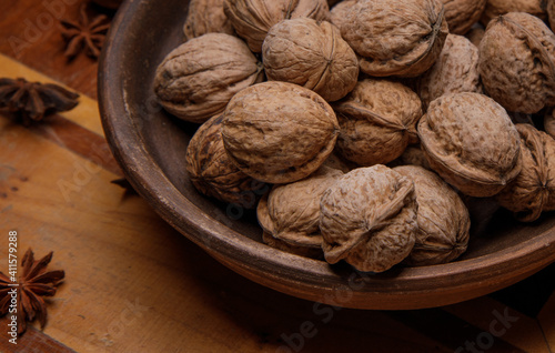 Nuts. whole walnuts in an earthenware dish on a dark wooden table. selective soft focus. 