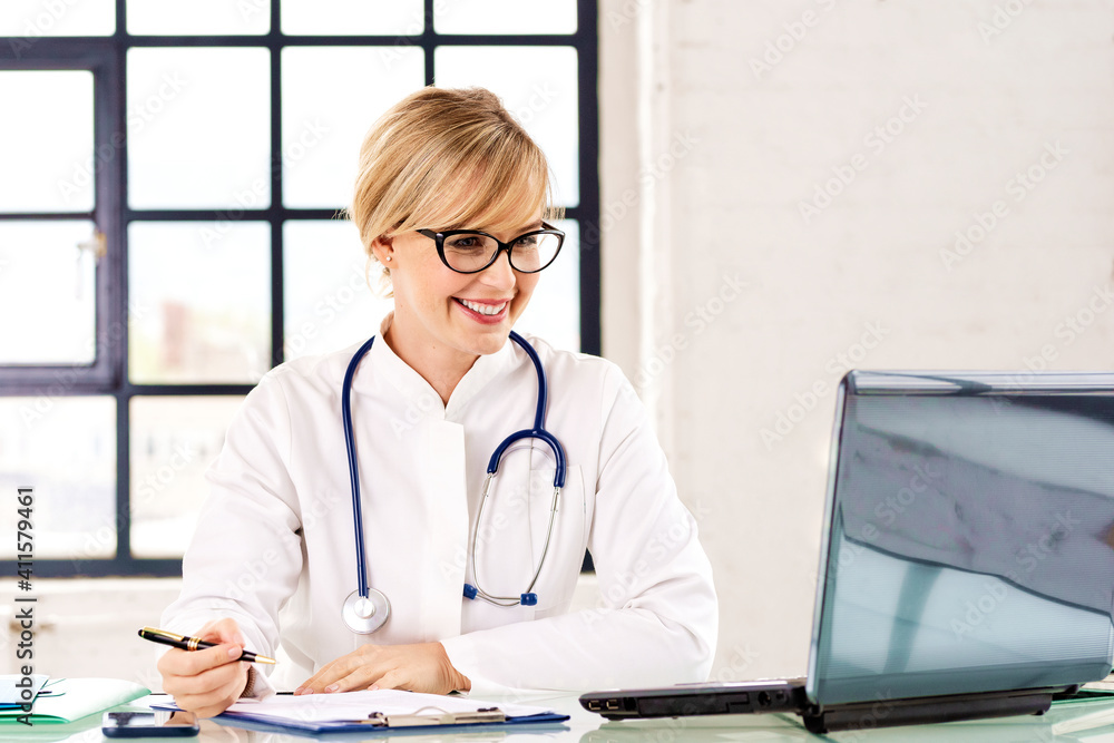 Portrait of female doctor working at desk in doctor's office Portrait of female doctor working at desk in doctor's office