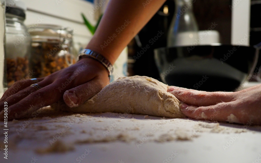 Fototapeta premium hands of a young woman with a bread dough in a white table