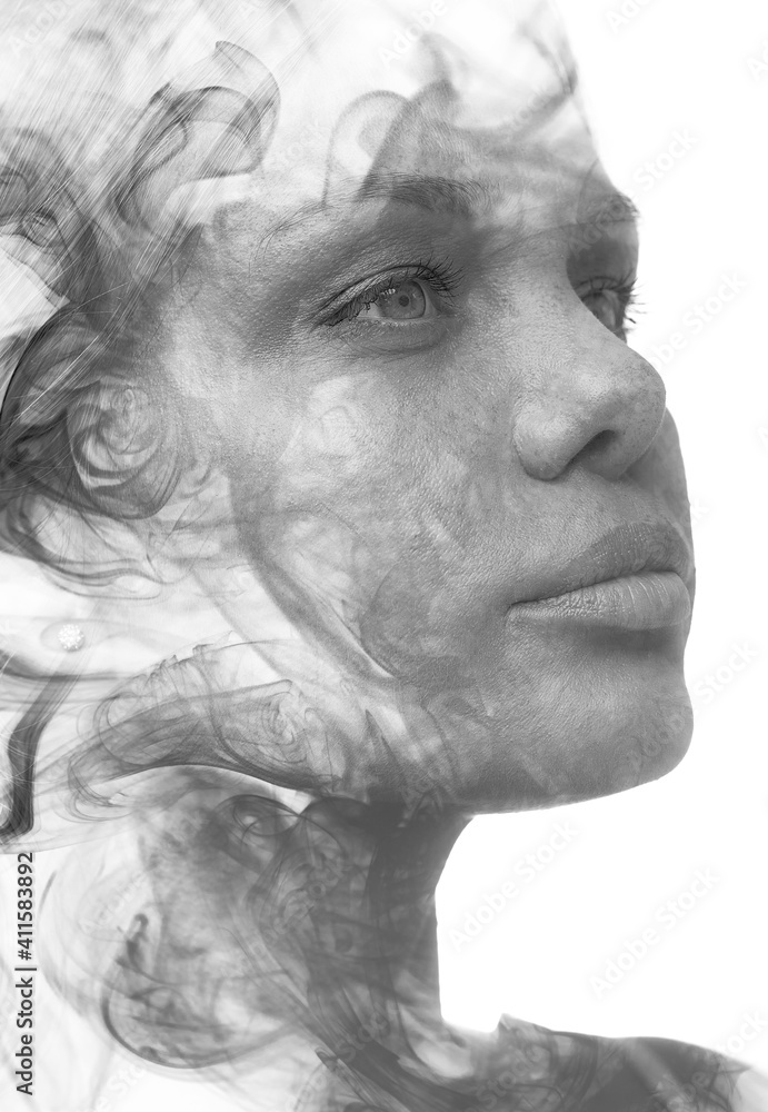 Obraz premium A confident young woman's black and white double exposure portrait close up combined with smoke swirls 