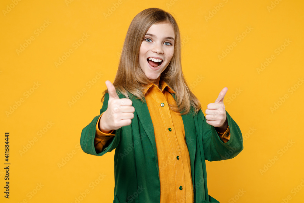 Little blonde happy smiling kid girl 12-13 years old wearing casual clothes green shirt show thumb up gesture isolated on yellow orange background children studio portrait Childhood lifestyle concept Little blonde happy smiling kid girl 12-13 years old wearing casual clothes green shirt show thumb up gesture isolated on yellow orange background children studio portrait Childhood lifestyle concept