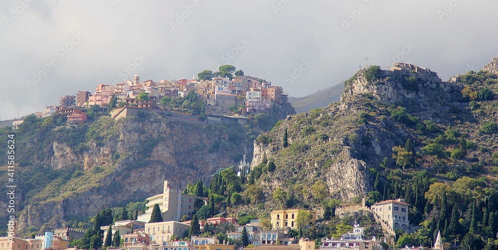 buildings, houses built high on the top of a mountain in eastern Sicily, rocky mountains descending into the sea
