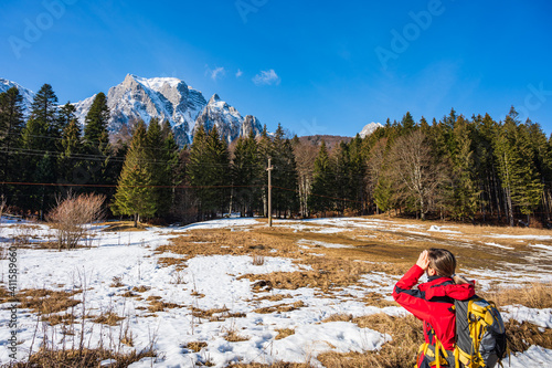 Obraz na płótnie Female hiker looking up to high rising mountain range in Romanian Carpathians w salonie