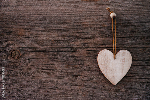 Valentine's Day background. Brown natural boards in grunge style with one wooden decorative hearts. Top view. Surface of table to shoot flat lay. Concept love, romantic relation. Copy space for text