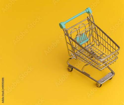 Empty shopping cart on yellow background.
