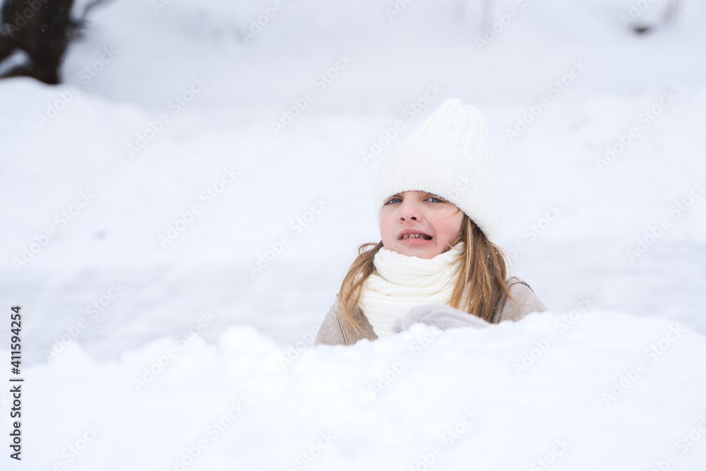 Beautiful little cute girl learn to skate on ice skating rink in park. Fall down and have fun. Stylish look, warm woolen coat, white hat, scarf, snood. Winter family activities, sport, games outdoors Beautiful little cute girl learn to skate on ice skating rink in park. Fall down and have fun. Stylish look, warm woolen coat, white hat, scarf, snood. Winter family activities, sport, games outdoors