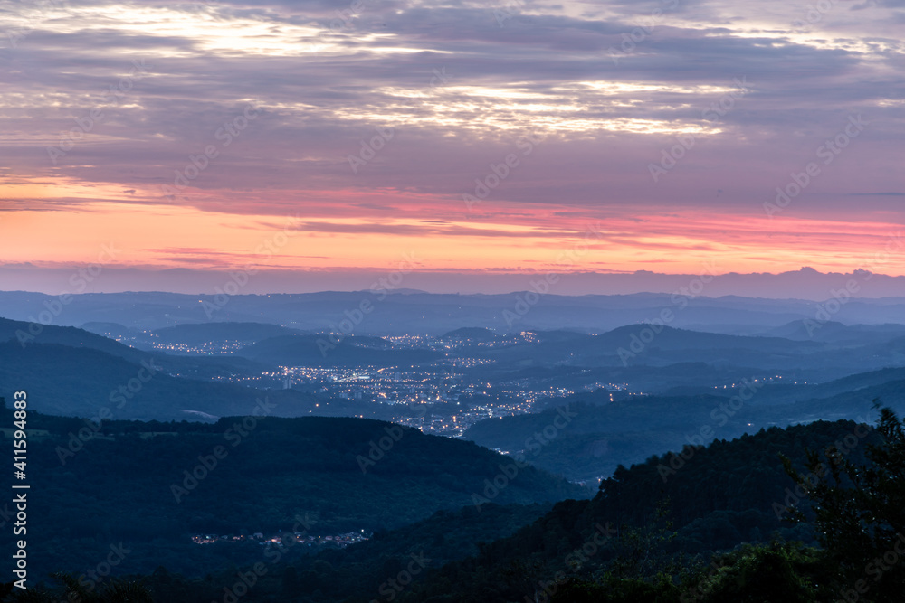 Sunset with trees, forest, valley and city lights