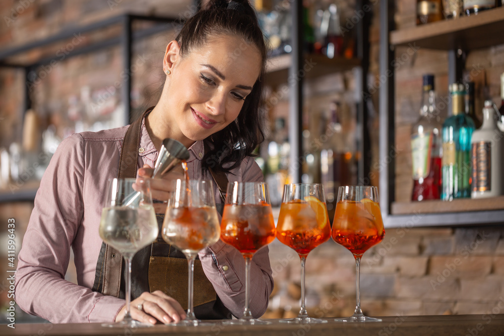 Happy bartender makes aperol spritz cocktail on a bar into five glasses Happy bartender makes aperol spritz cocktail on a bar into five glasses