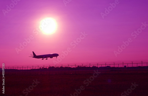 Pop art surreal styled silhouette of airplane taking off up to purple sky with bright sun