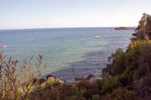 One of the coves along the Calanca bay with people taking their last swim in the sea on the hot summer evening.  Marina di Camerota, Italy. photo