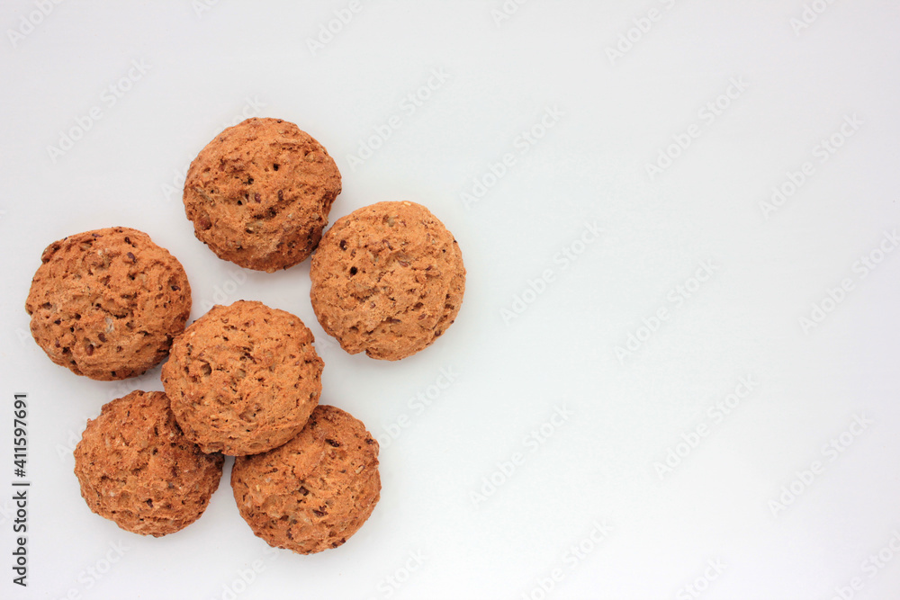Homemade oatmeal cookies on white table. Overhead view of oat biscuits on white background with copy space Homemade oatmeal cookies on white table. Overhead view of oat biscuits on white background with copy space