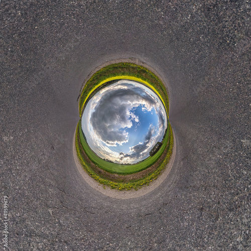 Inversion of blue little planet transformation of spherical panorama 360 degrees. Spherical abstract aerial view on road with awesome beautiful clouds. Curvature of space.