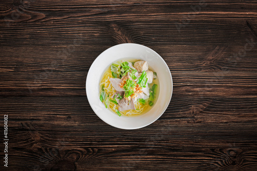 Pork noodles with meat ball on wooden background
