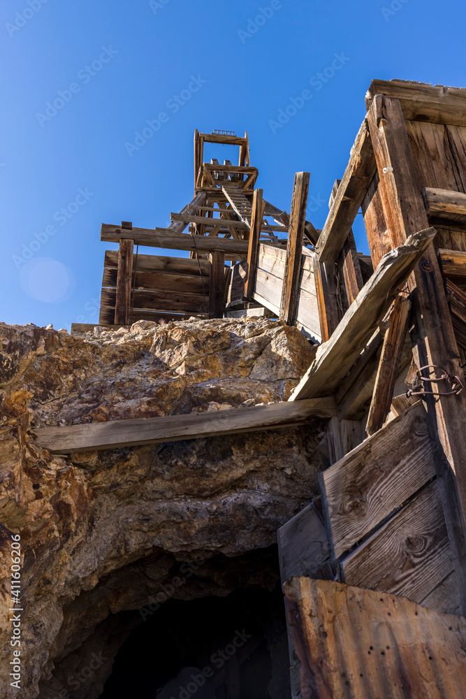 Fototapeta premium Low point of view looking up at a wooden mining head frame with mine entrance directly ahead