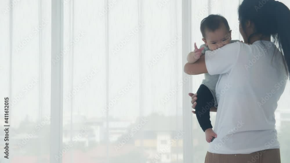 Young asian mother holding little baby girl and walking together in the bedroom at home, mom carry daughter and care, relationship of parent and child, toddler and parent, indoor, family concept. Young asian mother holding little baby girl and walking together in the bedroom at home, mom carry daughter and care, relationship of parent and child, toddler and parent, indoor, family concept.