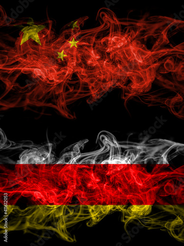 China, Chinese vs South Ossetia smoky mystic flags placed side by side. Thick colored silky abstract smoke flags.