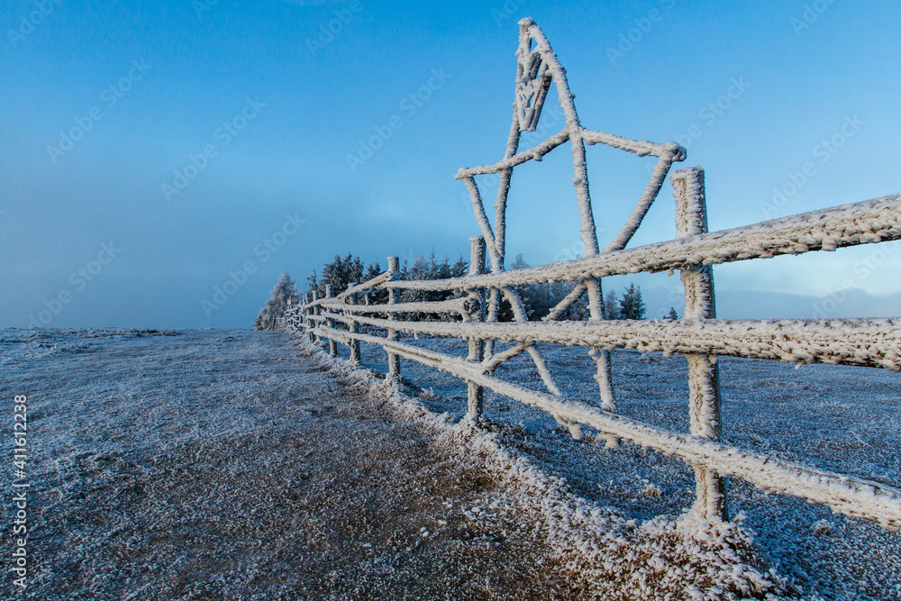 Frozen fence on a cold winter day in the mountains
