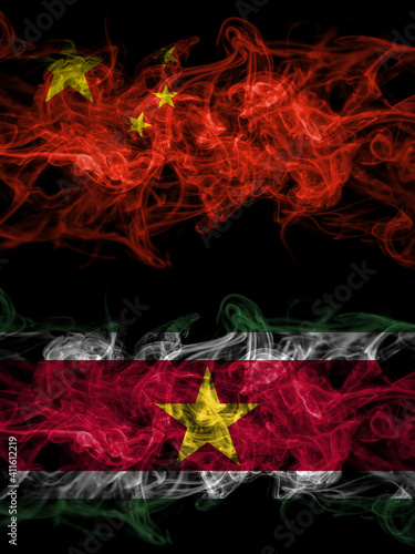 China, Chinese vs Suriname smoky mystic flags placed side by side. Thick colored silky abstract smoke flags.