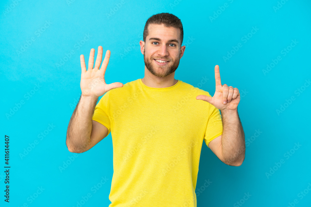 Young handsome caucasian man isolated on blue background counting seven with fingers Young handsome caucasian man isolated on blue background counting seven with fingers