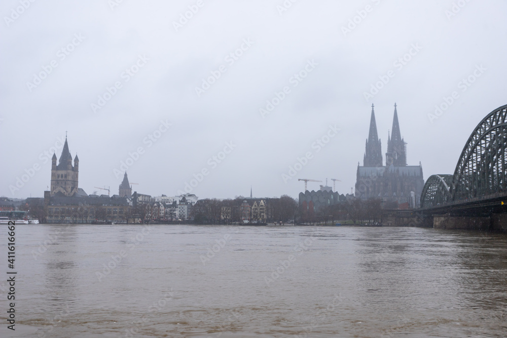 panorama of Cologne with cathedral great St. Martin and hohenzollern bridge at snowy weather. rhine river with high water