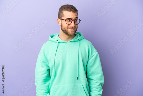 Young handsome caucasian man isolated on purple background . Portrait © luismolinero