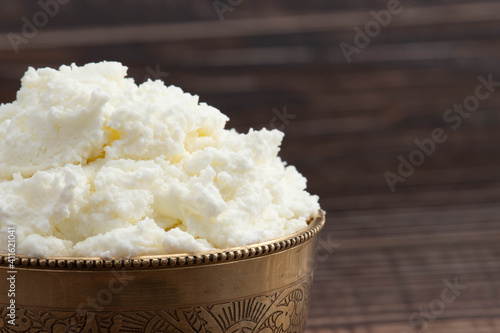 Detailed Closeup Of Freshly Churned White Butter Also Known As Safed Makhan Malai Or Homemade Makkhan In India Is Enjoyed With Breads Rotis Parathas And Sandwiches. Brown Background With Copy Space