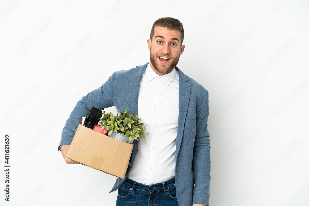 Young caucasian making a move while picking up a box full of things isolated on white background with surprise facial expression Young caucasian making a move while picking up a box full of things isolated on white background with surprise facial expression