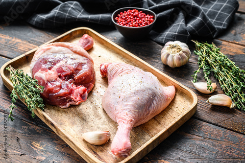 Duck  legs on cutting board, Raw meat. Dark background. Top view