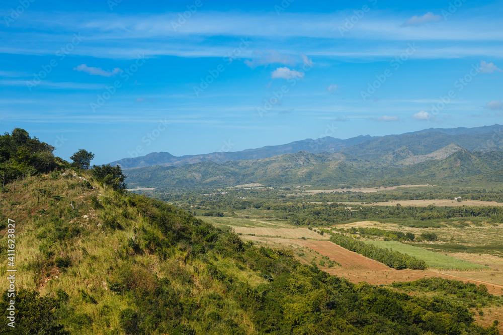 Mountains and blue sky with green grass in the foreground. Landscape in Cuba. Mountains in Latin America