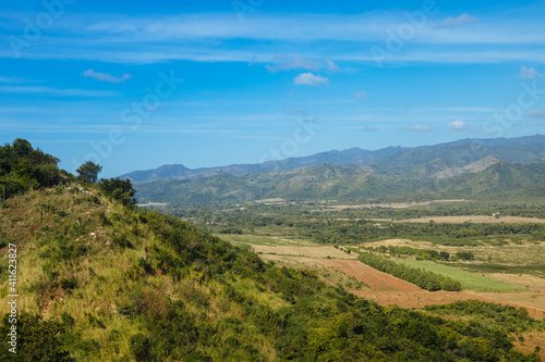 Mountains and blue sky with green grass in the foreground. Landscape in Cuba. Mountains in Latin America © Marianna