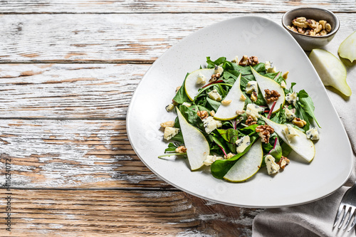 Diet salad with blue Gorgonzola cheese, pears, nuts, chard and arugula. White background. Top view. Copy space