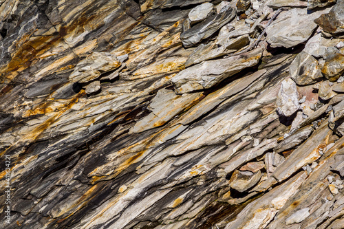 Verschiedenfarbige Gesteinsschichten in einer Felswand