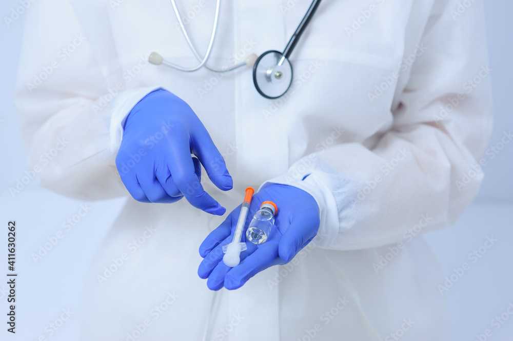 Doctor in medical gloves and a mask holds a vaccine in his hands Doctor in medical gloves and a mask holds a vaccine in his hands
