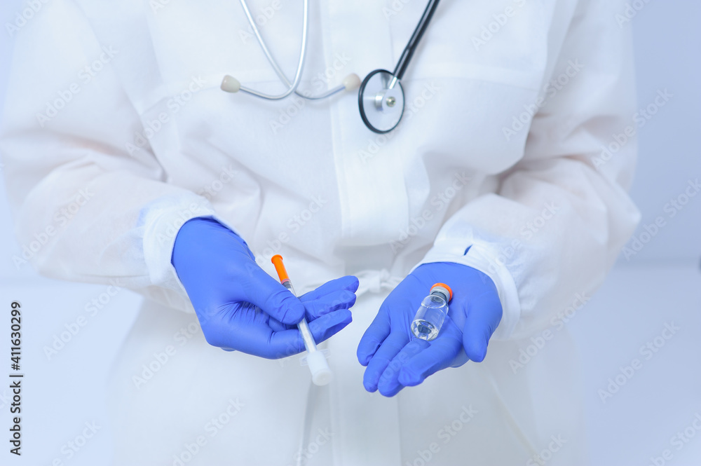 Doctor in medical gloves and a mask holds a vaccine in his hands Doctor in medical gloves and a mask holds a vaccine in his hands