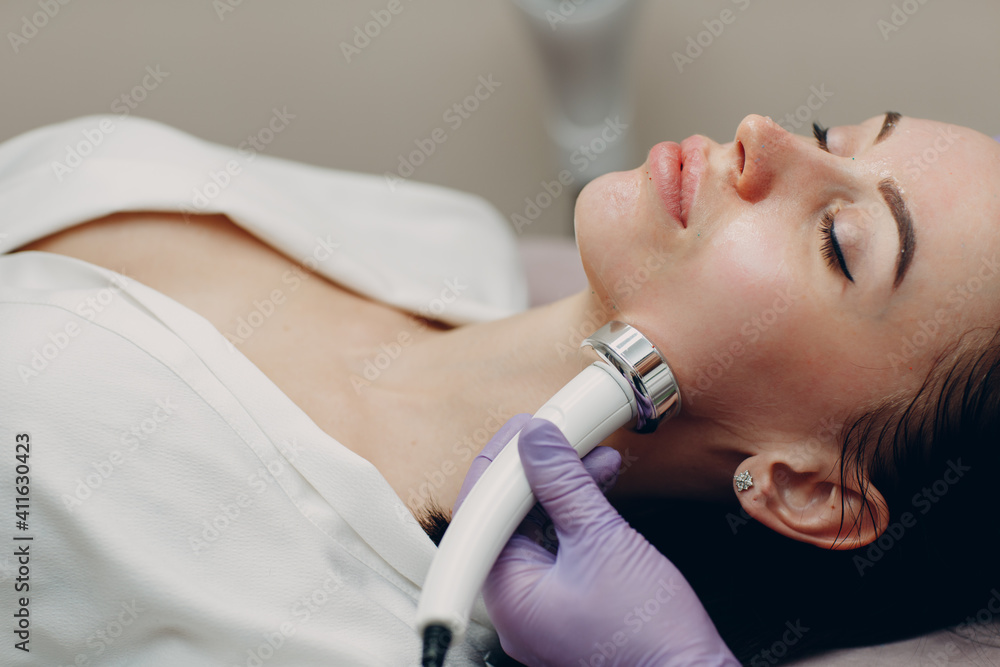 Young woman receiving electric RF lifting facial massage at beauty spa with electroporation equipment. Young woman receiving electric RF lifting facial massage at beauty spa with electroporation equipment.